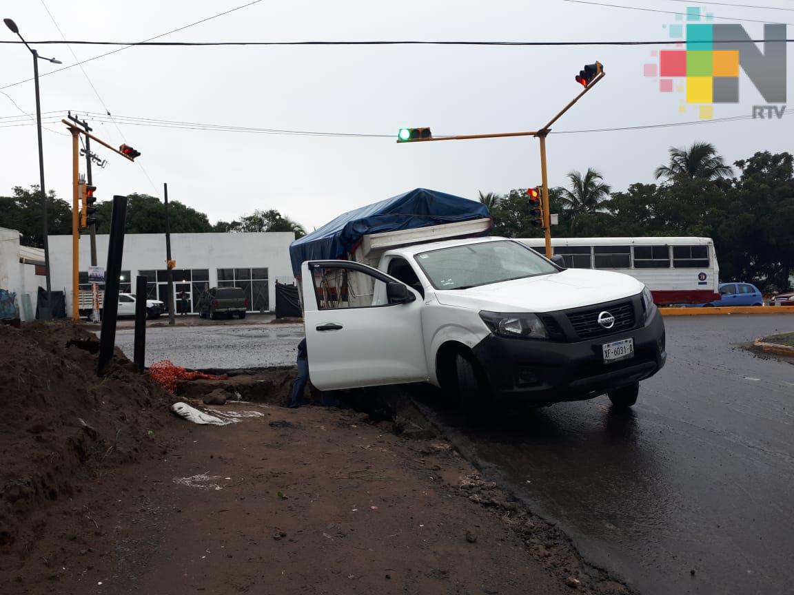 Camioneta cae en hoyo por reblandecimiento de pavimento en fraccionamiento del puerto