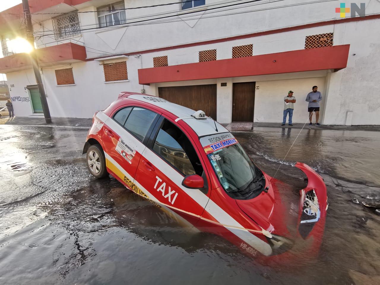 Taxi cae en hundimiento provocado por fuga de agua, en Veracruz