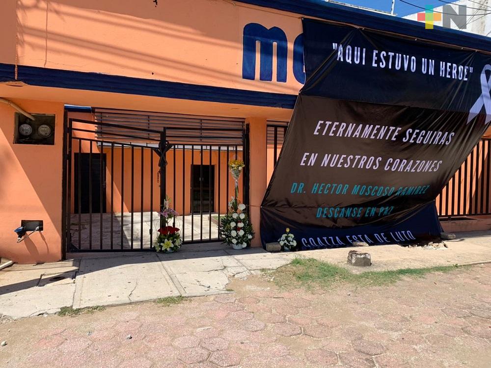 Afuera de clínica de Coatzacoalcos, colocan lona y arreglos florales en memoria del doctor Héctor Moscoso