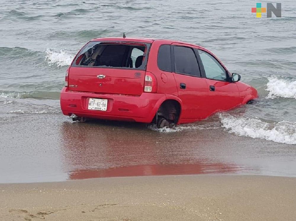 Automóvil atascado en playa de Coatzacoalcos; su dueño lo abandonó al no poder retirarlo