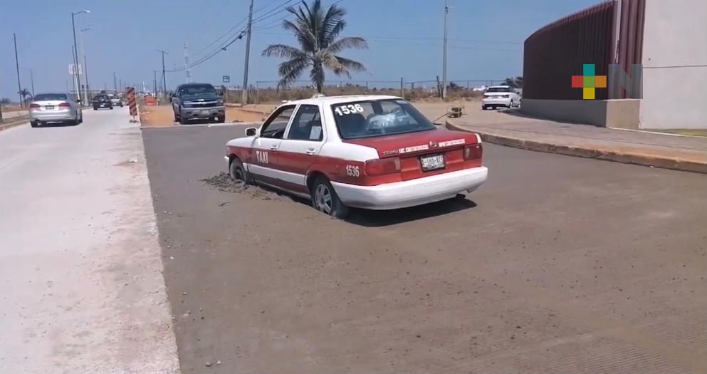 Taxi se hunde en calle recién rehabilitada de Coatzacoalcos