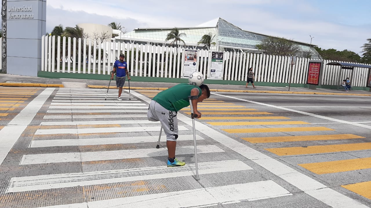 Amputados de sus piernas, dos jóvenes recorren el país dominando un balón de futbol para ganarse monedas