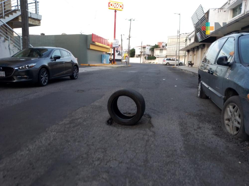 Con neumático señalan bache en costado del mercado Zaragoza de Veracruz