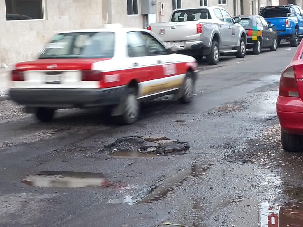 Aguas negras provocan bache cerca de central camionera de Veracruz puerto