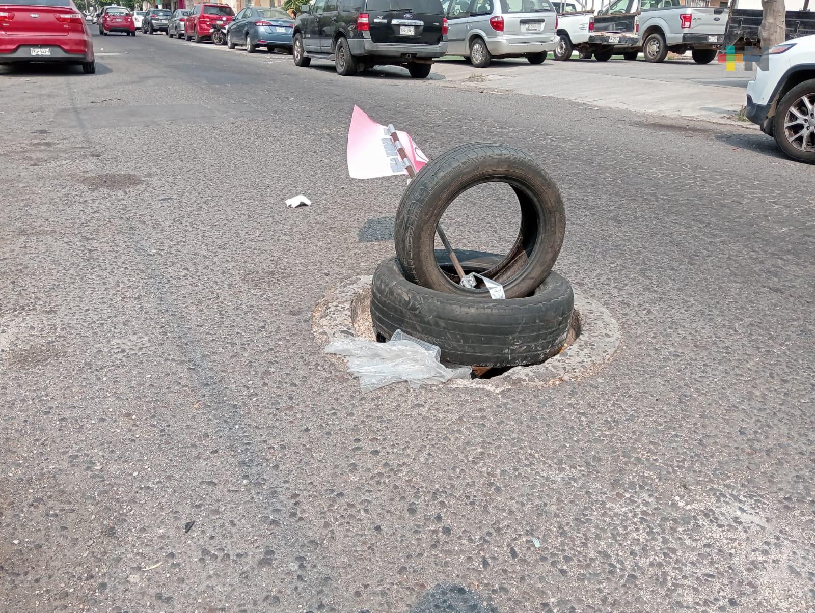Vecinos señalizan registro sin tapa con neumáticos; peligro y hedor que no se atiende