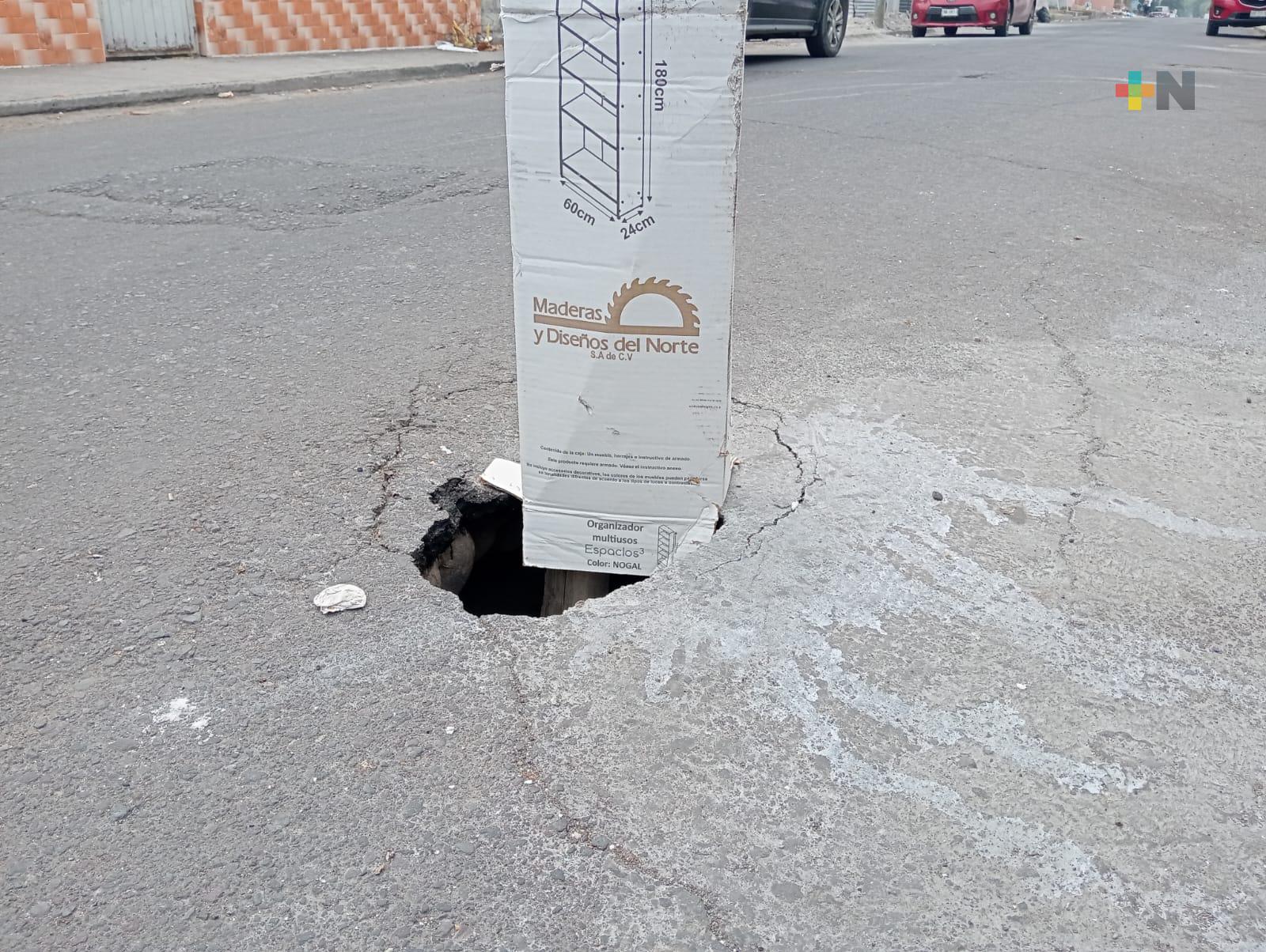 Con un palo señalan hundimiento en calle Yáñez de Veracruz puerto
