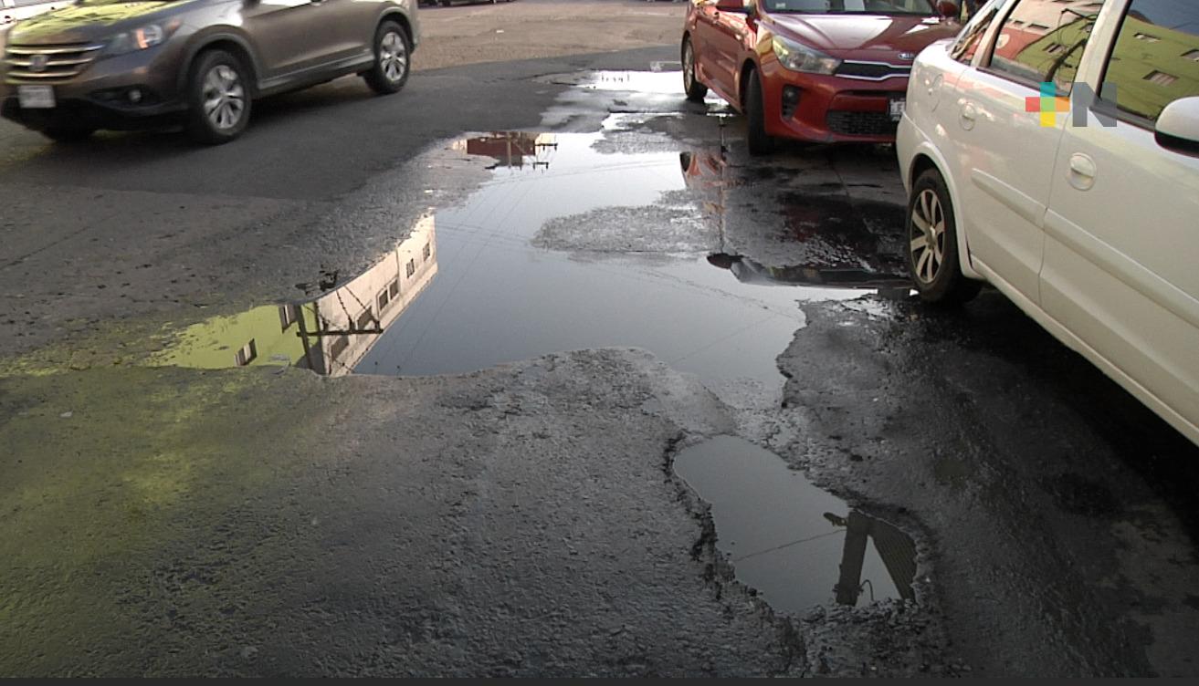 Aguas sucias ocultan baches en zona de mercados de Veracruz puerto, alertan automovilistas