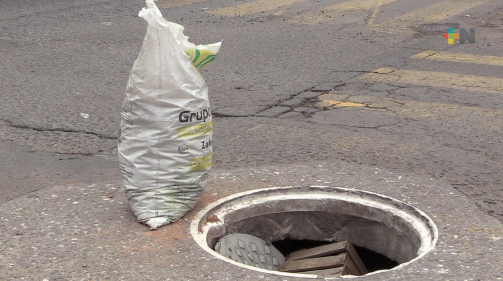 Vecinos improvisan señalética para indicar registro sin tapa